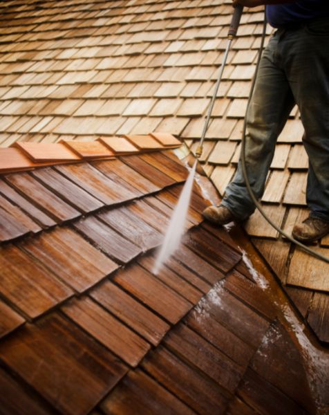 man cleaning roof shingles with pressure washer chesapeake va